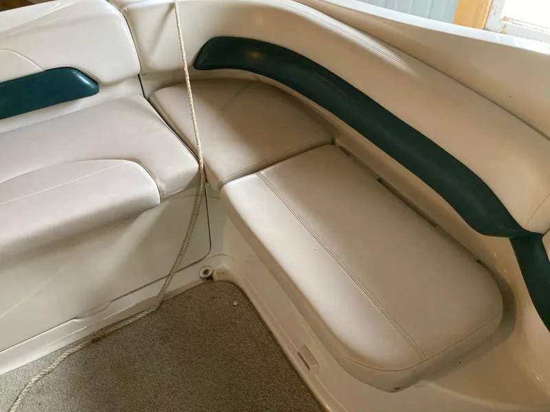 Slide: The Image of Interior seating of a 1996 Regal 7.0 SE boat, featuring white and green upholstery. - 8
