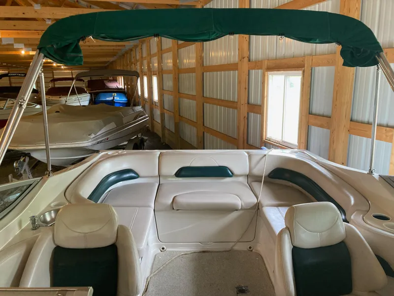 Slide: The Image of 1996 Regal 7.0 SE boat interior in storage, featuring white and green seating. - 9