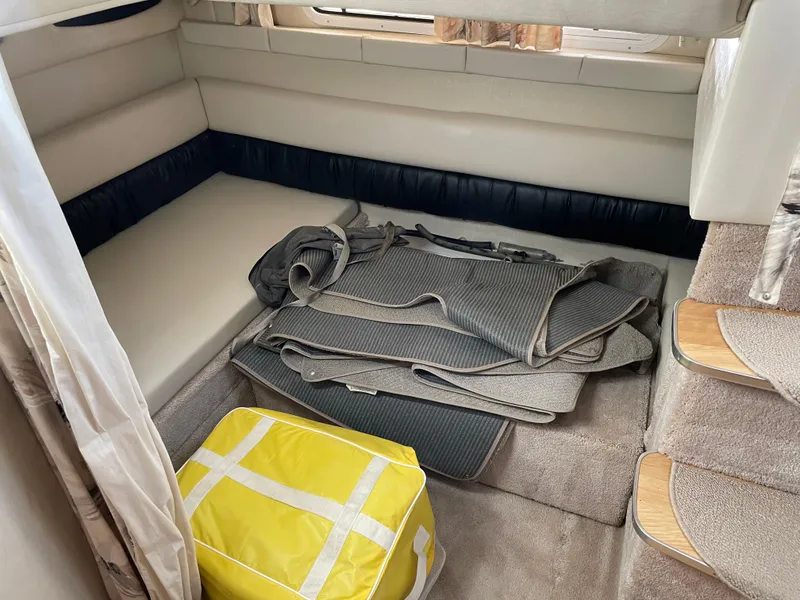 Slide: The Image of Interior cabin of 1999 Wellcraft 3600 Martinique with seating, carpet, and yellow storage bag. - 13