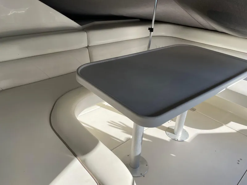 Slide: The Image of Interior seating area of a 1999 Wellcraft 3600 Martinique boat with a table. - 19