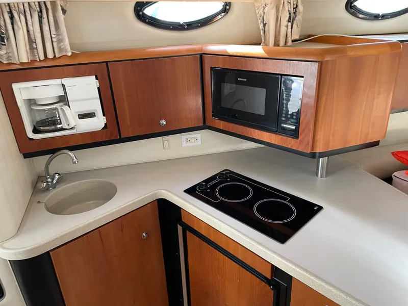 Slide: The Image of 1999 Wellcraft 3600 Martinique yacht kitchen with microwave, coffee maker, stove, and sink. - 8
