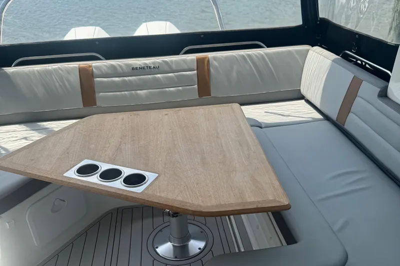 Slide: The Image of Interior of 2023 Beneteau Gran Turismo 32 with wooden table and cushioned seating. - 10