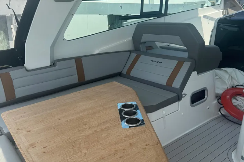 Slide: The Image of Interior of 2023 Beneteau Gran Turismo 32, featuring seating and a wooden table with cup holders. - 13