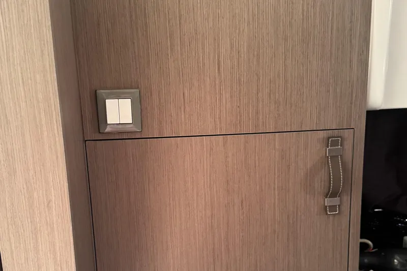 Slide: The Image of Wooden cabinet with leather handle and light switch on Beneteau Gran Turismo 32, 2023 model. - 28