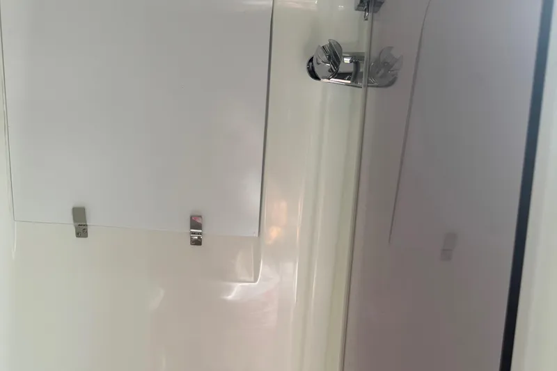 Slide: The Image of Interior of 2023 Beneteau Gran Turismo 32 yacht, featuring sleek white paneling and chrome fixtures. - 30