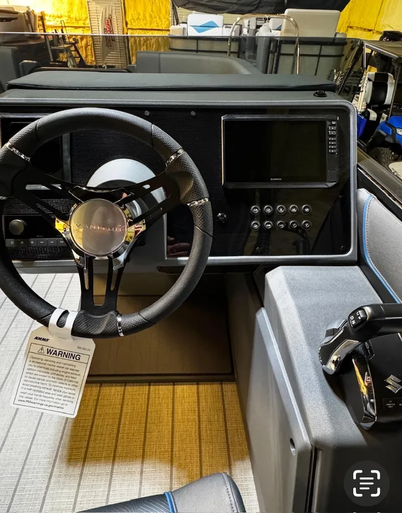 Slide: The Image of 2025 Manitou Explore boat dashboard with steering wheel, control panel, and display screen. - 4