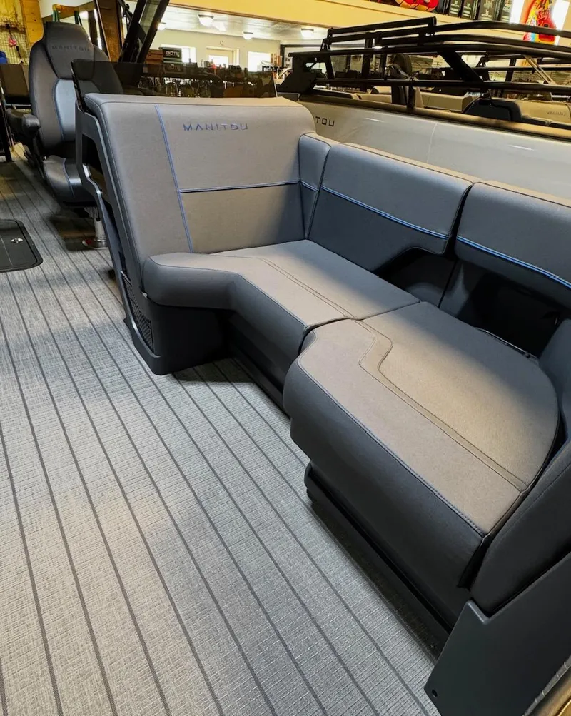 Slide: The Image of 2025 Manitou Explore boat interior with sleek gray seating and modern design. - 5