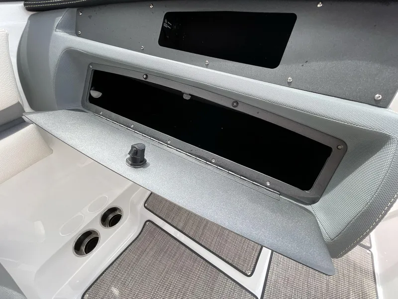 Slide: The Image of 2018 Cobalt CS23 Surf boat interior storage compartment with open lid and cup holders. - 18