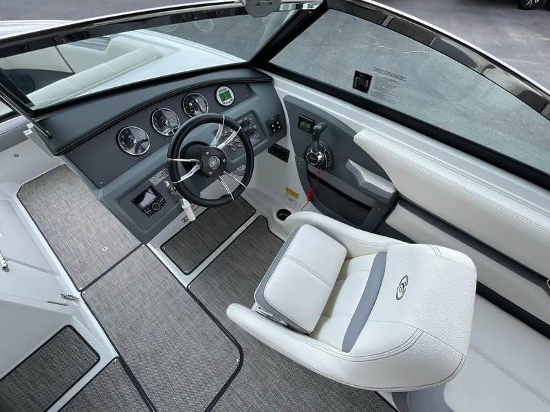 Slide: The Image of 2018 Cobalt CS23 Surf boat interior with steering wheel and dashboard controls. - 23