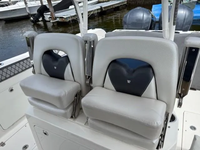 Slide: The Image of 2018 Wellcraft 302 Fisherman boat seats, white and black, docked by the water. - 12