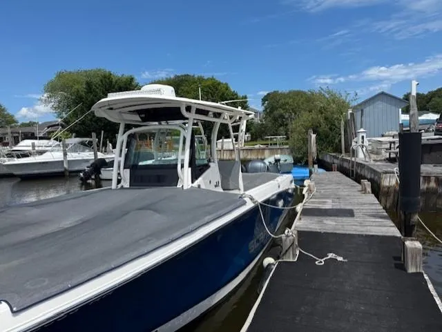 Slide: The Image of 2018 Wellcraft 302 Fisherman boat docked at a marina under a clear blue sky. - 3