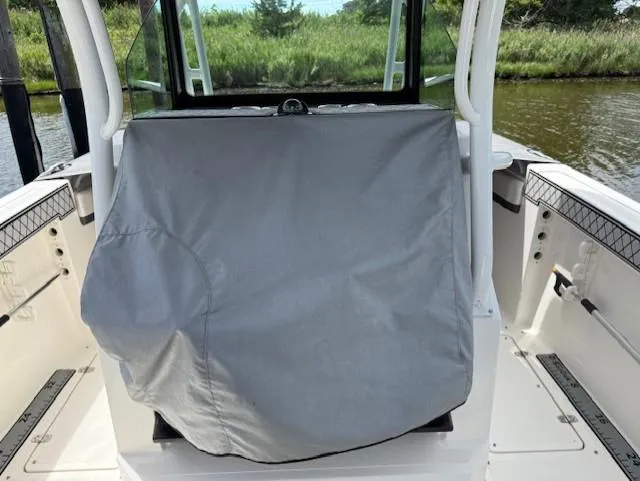 Slide: The Image of 2018 Wellcraft 302 Fisherman boat interior with covered console, docked by lush greenery. - 5