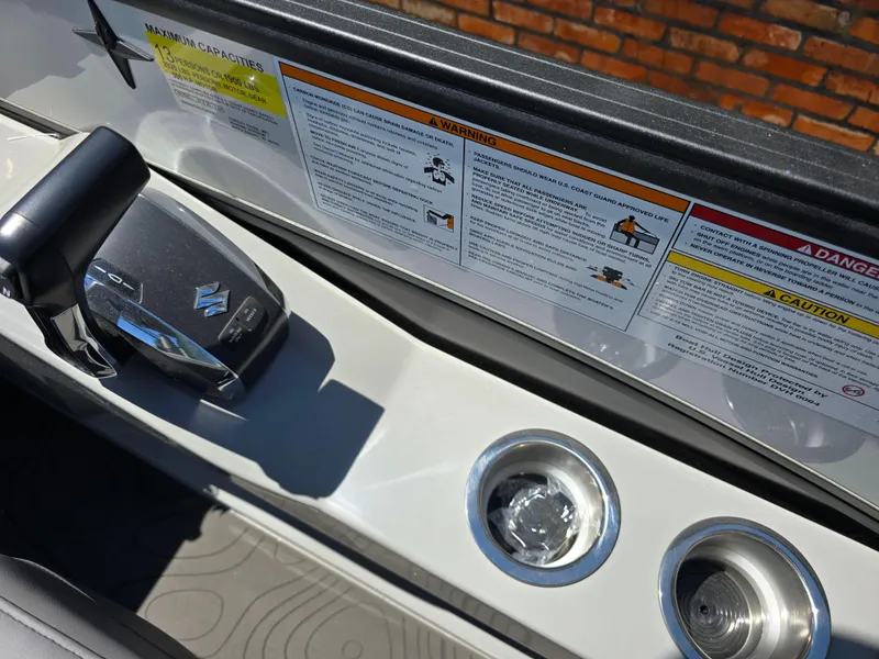 Slide: The Image of 2026 Berkshire STS 25 RFX 3.0+ boat controls with warning labels and cup holders. - 22