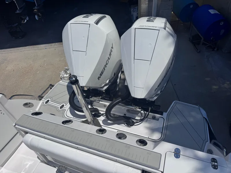 Slide: The Image of 2026 Blackfin 272 DC boat with dual Mercury outboard engines, docked on a sunny day. - 10