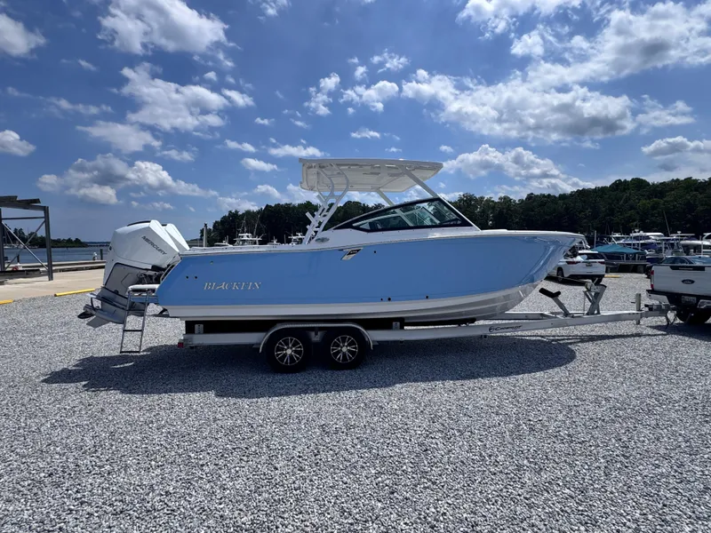 Slide: The Image of 2026 Blackfin 272 DC boat on trailer, parked at marina under blue sky. - 5
