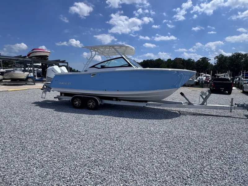 Slide: The Image of 2026 Blackfin 272 DC boat on trailer under blue sky at marina. - 8