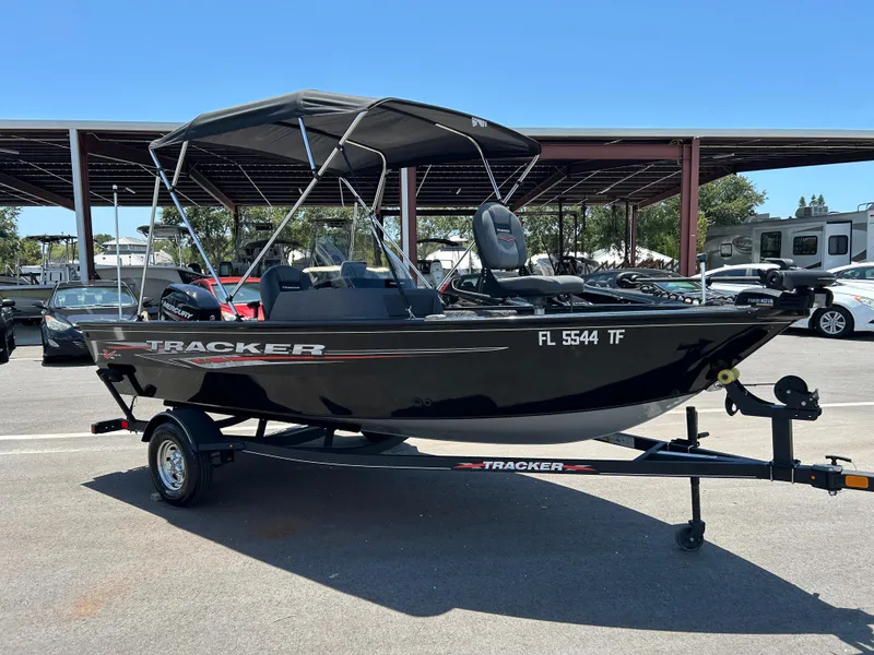 The Image of 2022 Tracker Pro Guide V-16 SC boat on trailer, parked outdoors. - 1