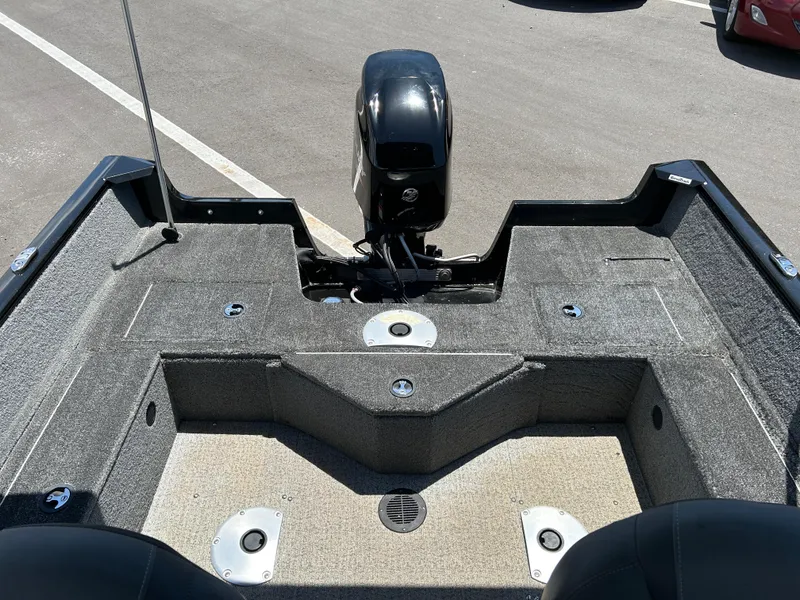 Slide: The Image of 2022 Tracker Pro Guide V-16 SC boat interior with motor, carpeted deck, and seating area. - 11