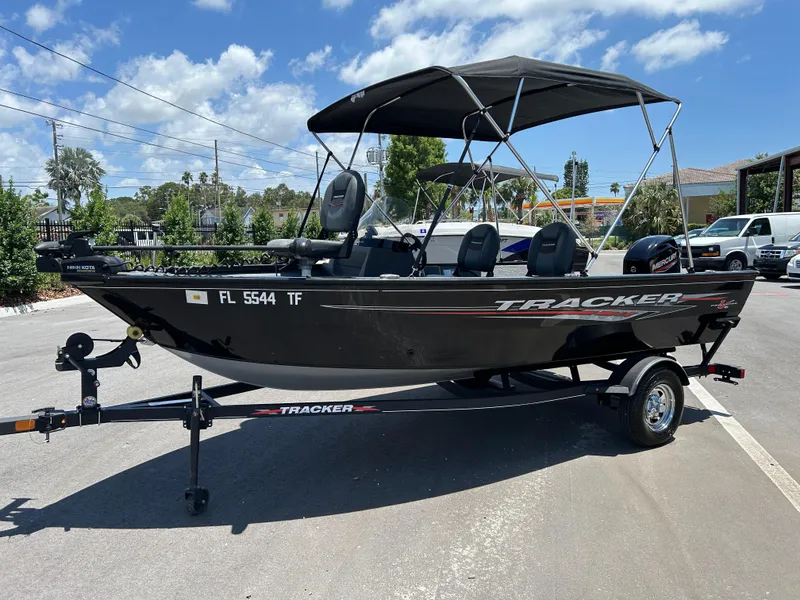 Slide: The Image of 2022 Tracker Pro Guide V-16 SC boat on trailer, parked outdoors under clear sky. - 5