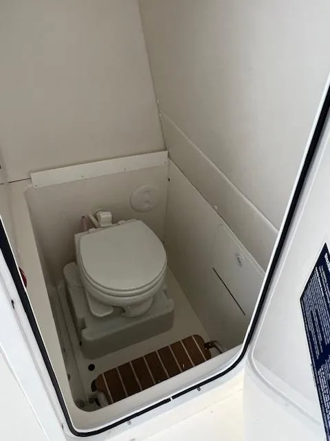 Slide: The Image of 2015 Regulator 23 Forward Seating boat interior with compact marine toilet. - 17