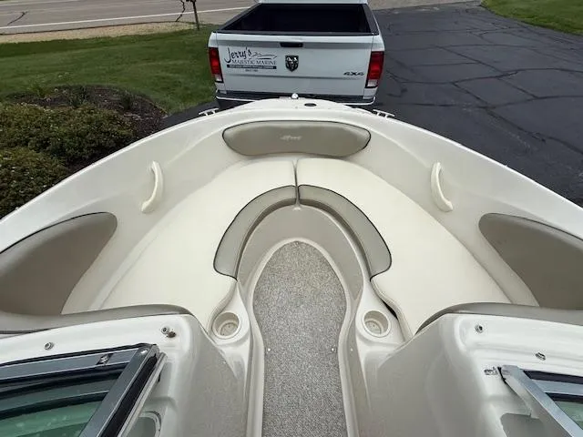Slide: The Image of 2005 Sea Ray 200 Sport boat interior with seating, parked near a pickup truck. - 11