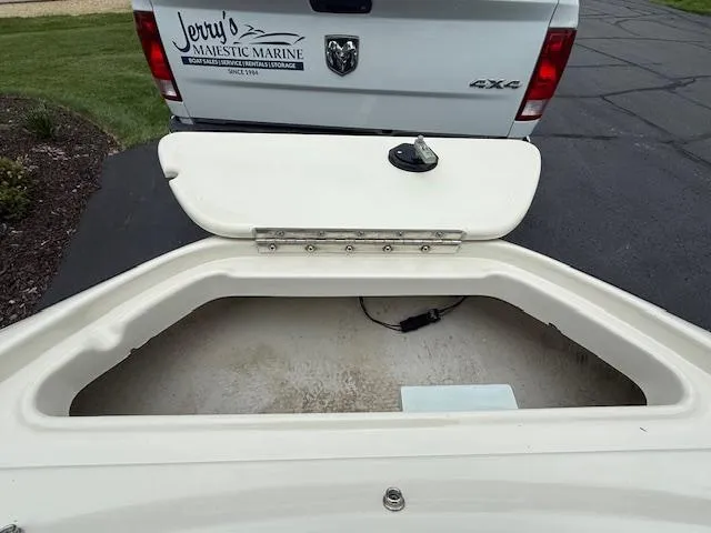 Slide: The Image of Open storage compartment of a 2005 Sea Ray 200 Sport boat near a parked truck. - 12