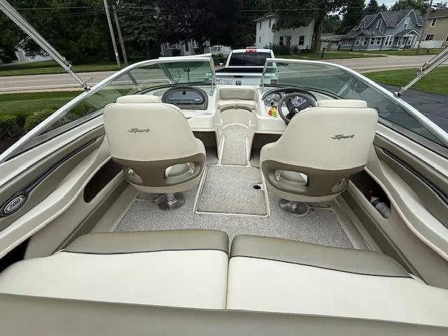 Slide: The Image of 2005 Sea Ray 200 Sport boat interior with beige seating and dashboard view. - 2