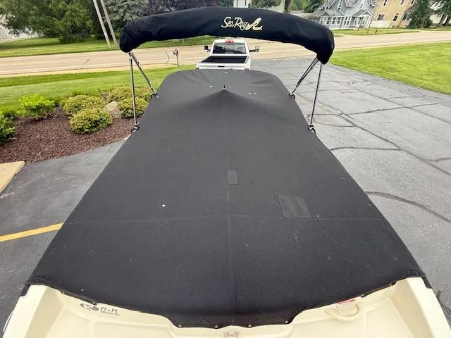 Slide: The Image of 2005 Sea Ray 200 Sport boat with black cover, parked on driveway. - 22