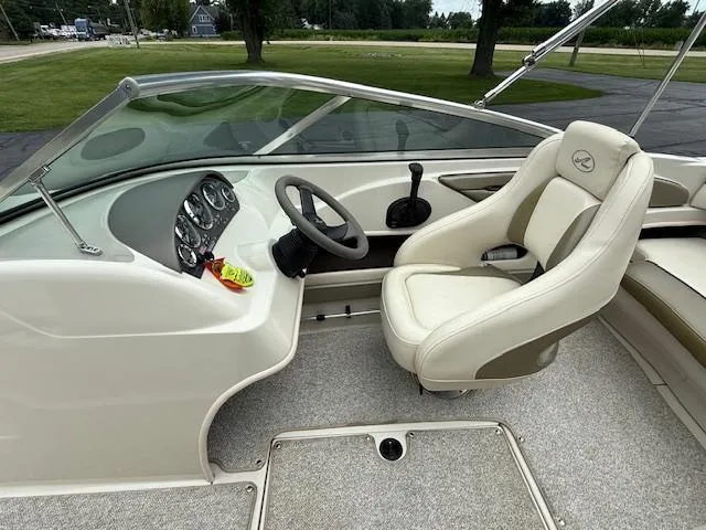 Slide: The Image of 2005 Sea Ray 200 Sport boat interior with steering wheel and beige seating. - 3
