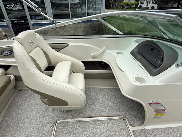 Slide: The Image of 2005 Sea Ray 200 Sport boat interior with white seating and dashboard. - 6