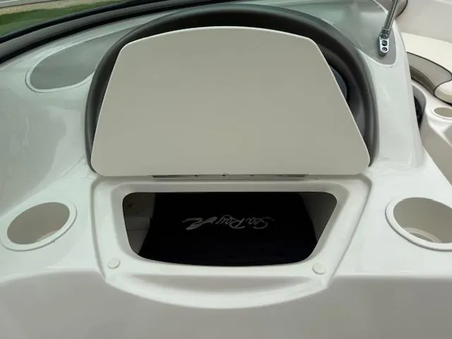 Slide: The Image of 2005 Sea Ray 200 Sport dashboard with storage compartment and cup holders. - 7
