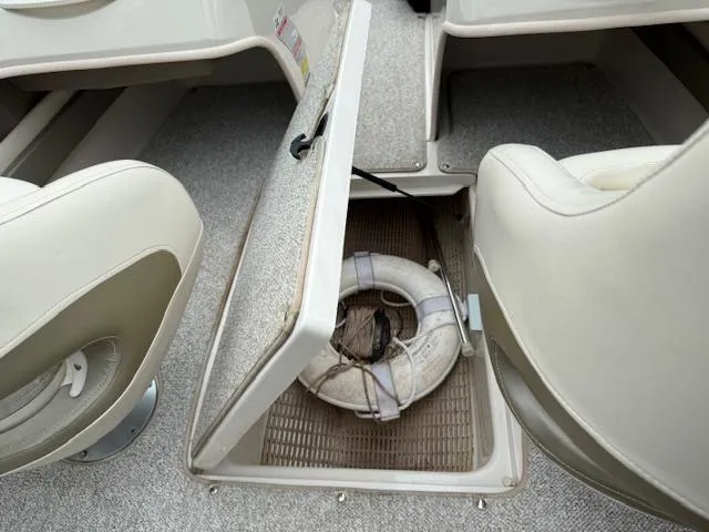 Slide: The Image of 2005 Sea Ray 200 Sport boat interior with open storage compartment and life preserver. - 9