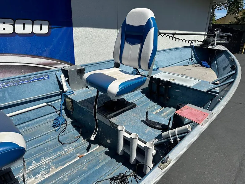 Slide: The Image of 1998 Klamath 14 DLX boat interior with blue and white seating and fishing rod holders. - 10