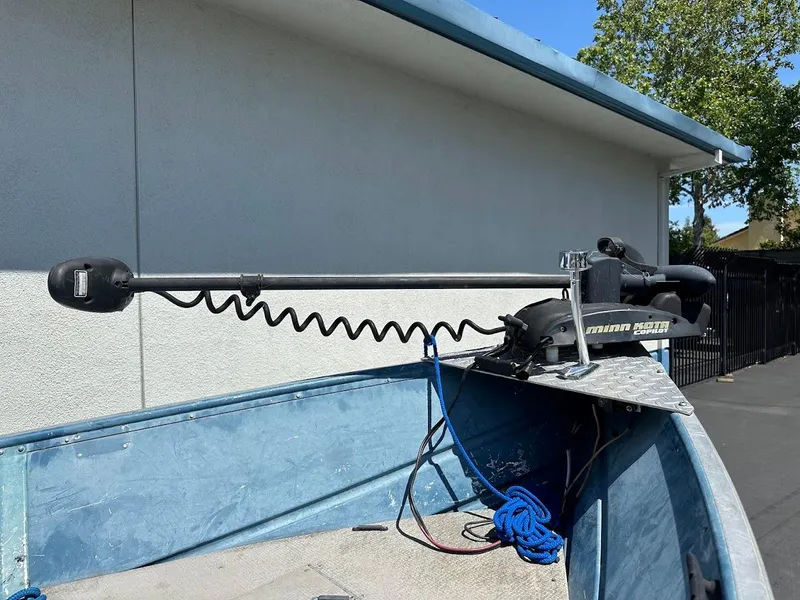 Slide: The Image of 1998 Klamath 14 DLX boat with Minn Kota trolling motor, docked outdoors. - 15