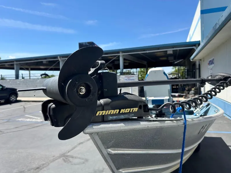 Slide: The Image of 1998 Klamath 14 DLX boat with Minn Kota motor in a parking lot. - 16