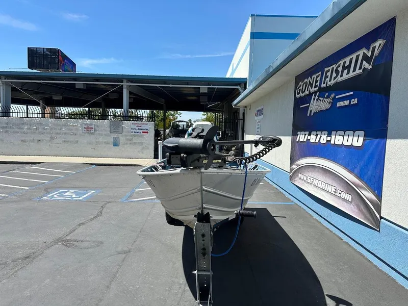 Slide: The Image of 1998 Klamath 14 DLX boat parked outside Gone Fishin' Marine store. - 3