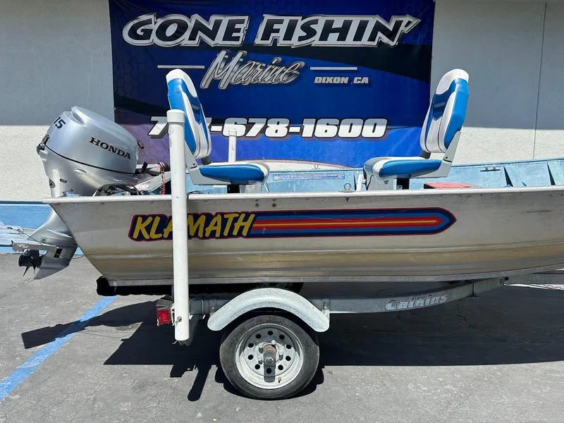 Slide: The Image of 1998 Klamath 14 DLX boat with Honda motor on trailer, displayed at Gone Fishin' Marine. - 5