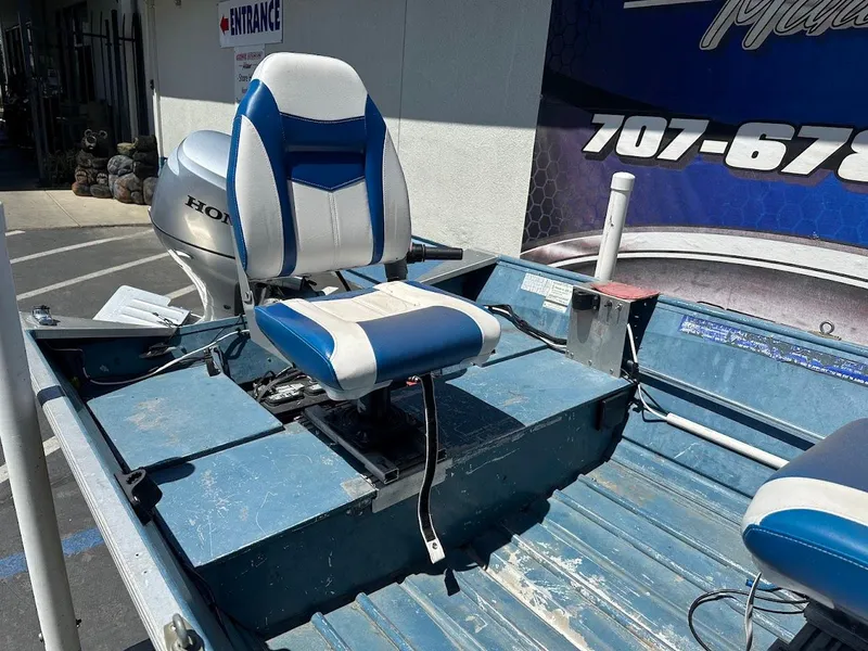 Slide: The Image of 1998 Klamath 14 DLX boat with blue and white seating and Honda outboard motor. - 9