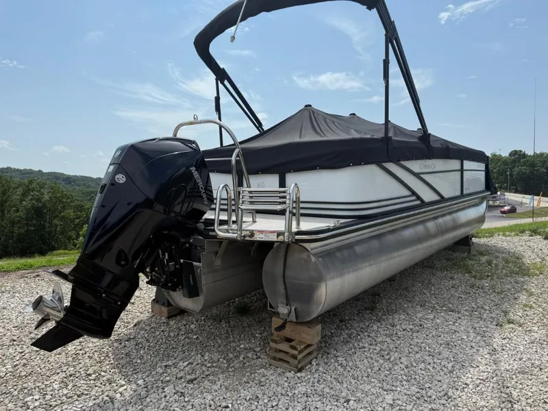 Slide: The Image of 2022 Cypress Cay Cabana 240 pontoon boat with Mercury outboard motor on gravel. - 2