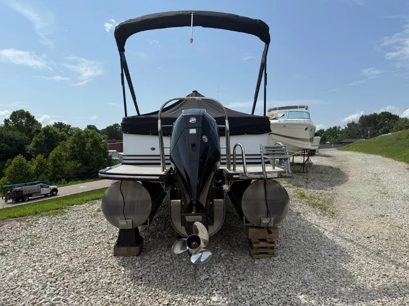 Slide: The Image of 2022 Cypress Cay Cabana 240 pontoon boat on gravel, rear view with outboard motor. - 3
