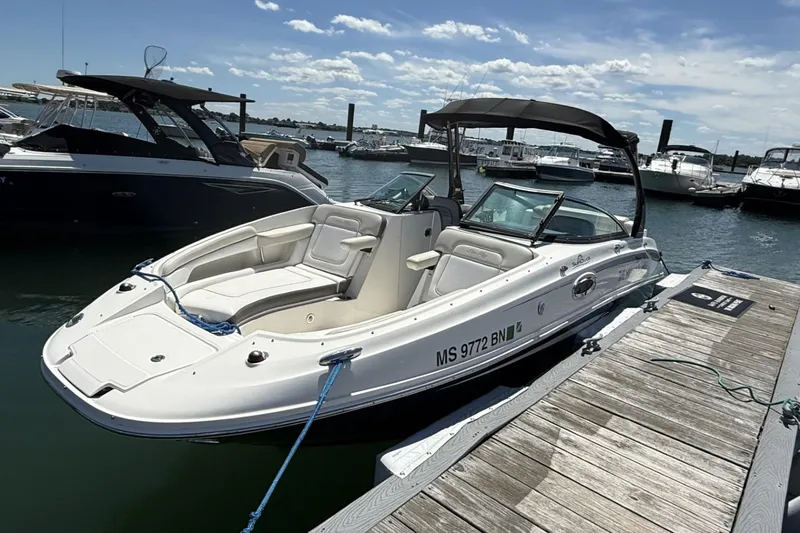 Slide: The Image of 2013 Sea Ray 260 Sundeck boat docked at marina under clear sky. - 2