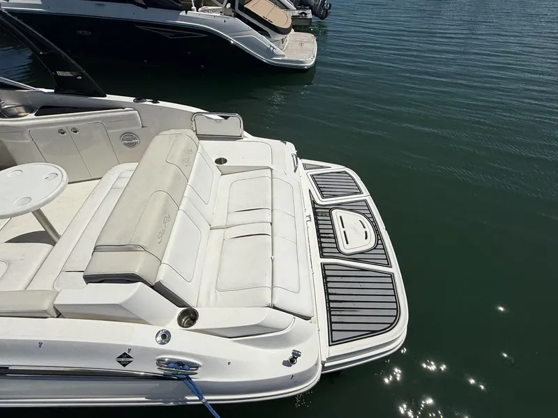 Slide: The Image of 2013 Sea Ray 260 Sundeck boat with spacious seating and swim platform on calm water. - 3
