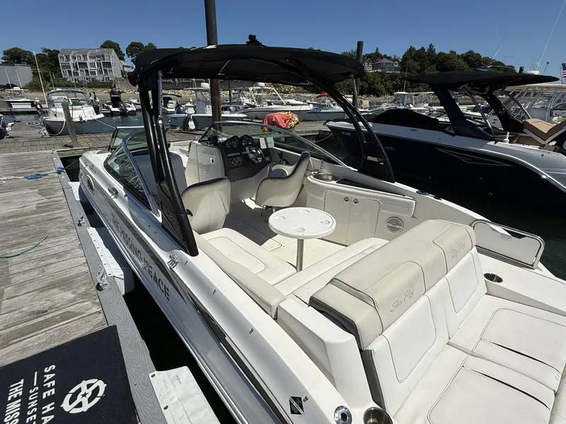 Slide: The Image of 2013 Sea Ray 260 Sundeck boat docked at marina, featuring spacious seating and canopy. - 4