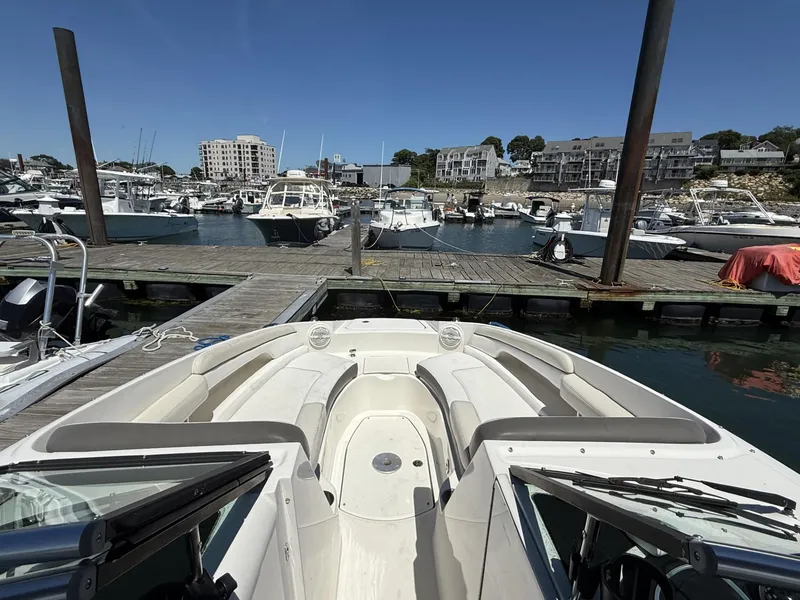 Slide: The Image of 2013 Sea Ray 260 Sundeck docked at a marina with boats and buildings in the background. - 5