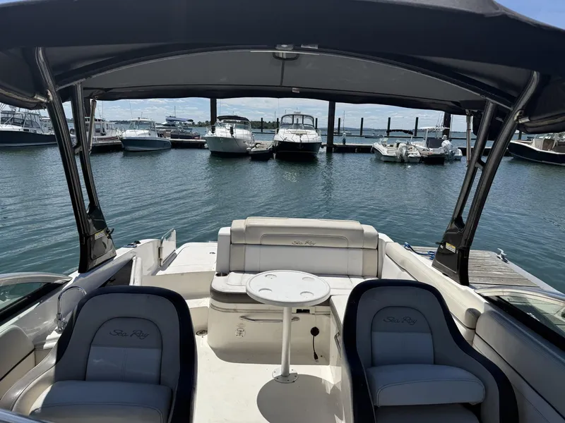 Slide: The Image of 2013 Sea Ray 260 Sundeck interior view at marina, featuring seating and table. - 6