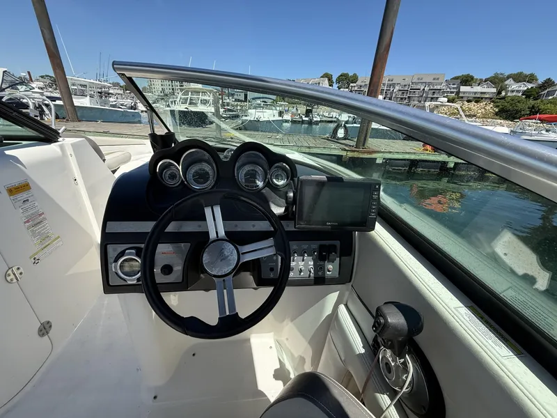 Slide: The Image of 2013 Sea Ray 260 Sundeck dashboard with steering wheel and navigation system at marina. - 7