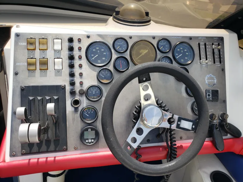 Slide: The Image of Control panel of a 1990 Fountain 27 Fever boat with steering wheel and gauges. - 2