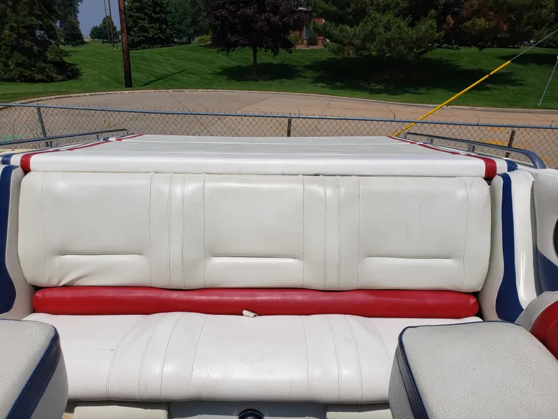 Slide: The Image of 1990 Fountain 27 Fever boat interior with white and red seating, parked outdoors. - 5