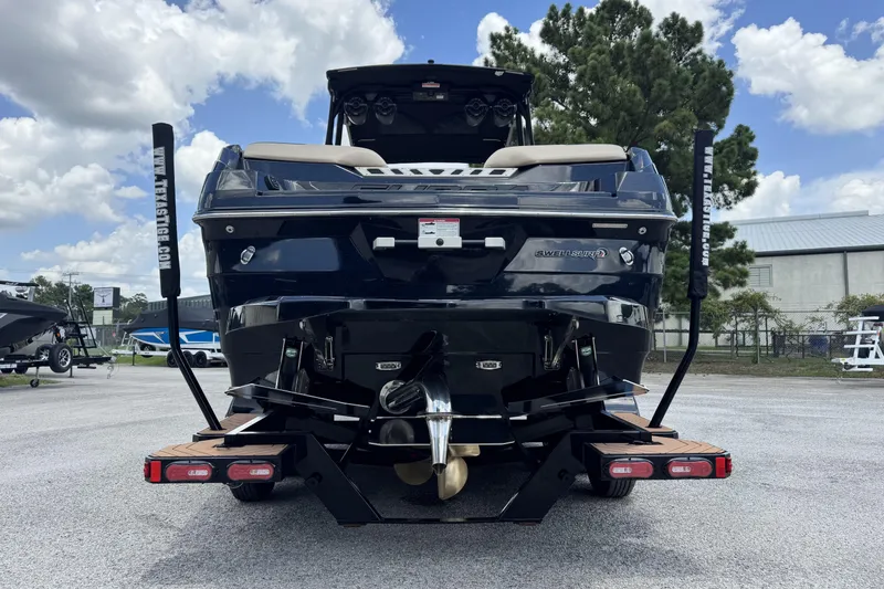 Slide: The Image of 2020 Supra SE 450 boat rear view, parked outdoors under a cloudy sky. - 3