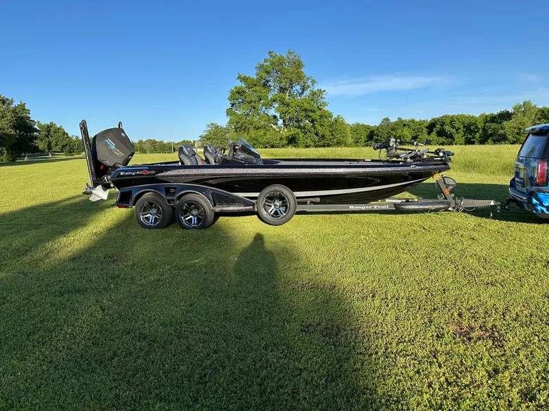 Slide: The Image of 2023 Ranger Z521R boat on trailer in grassy field, sunny day. - 2